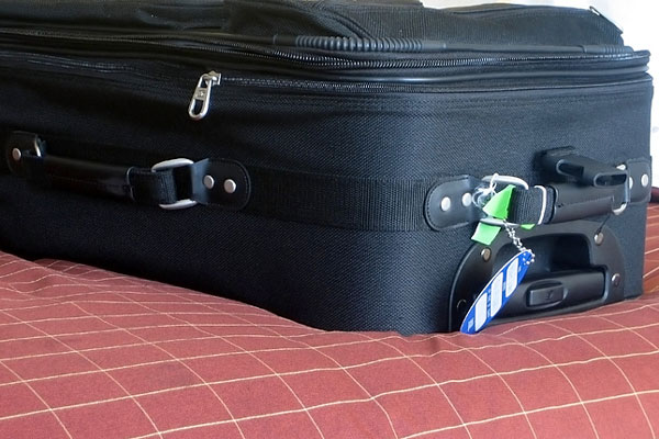 suitcase on a hotel room bed suitcase on a hotel room bed
